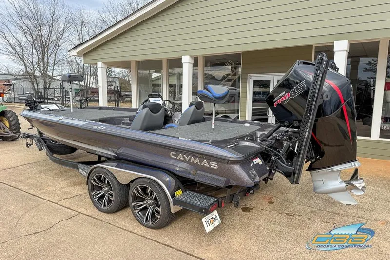 Slide: The Image of 2023 Caymas CX 21 PRO boat on trailer, parked outside a building. - 2