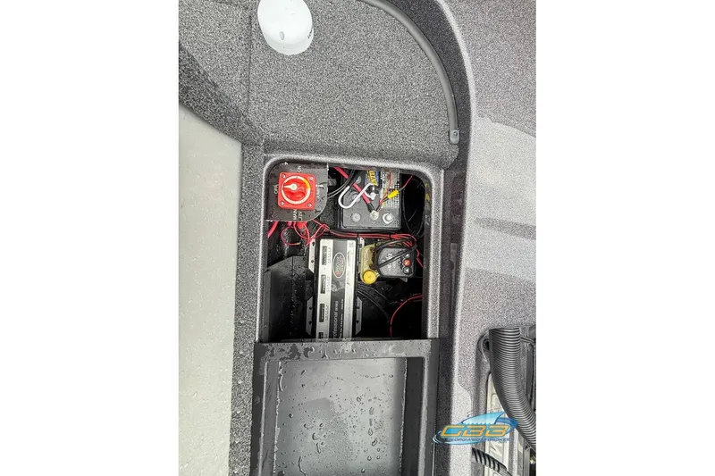Slide: The Image of 2023 Caymas CX 21 PRO boat battery compartment with wiring and switches. - 27