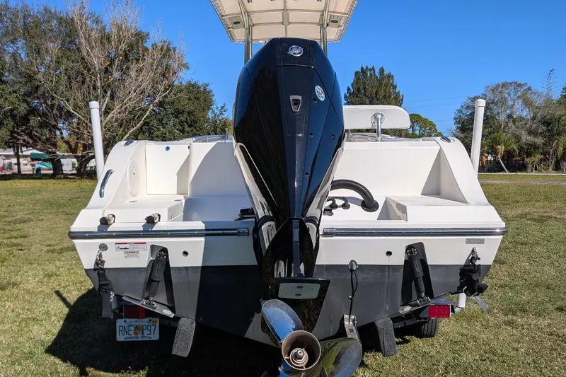 Slide: The Image of 2019 Cobia 237 Center Console boat with powerful outboard motor on grassy area. - 6