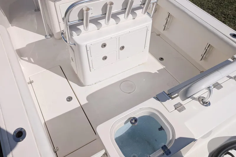 Slide: The Image of 2019 Cobia 237 Center Console boat interior with storage compartments and rod holders. - 7