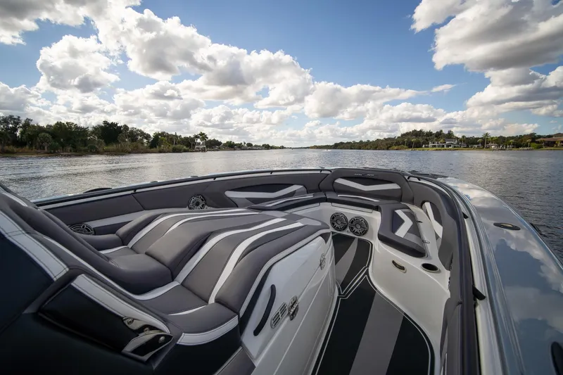 Slide: The Image of Luxurious MTI V42 boat interior with sleek seating, cruising on a scenic lake under a cloudy sky. - 10
