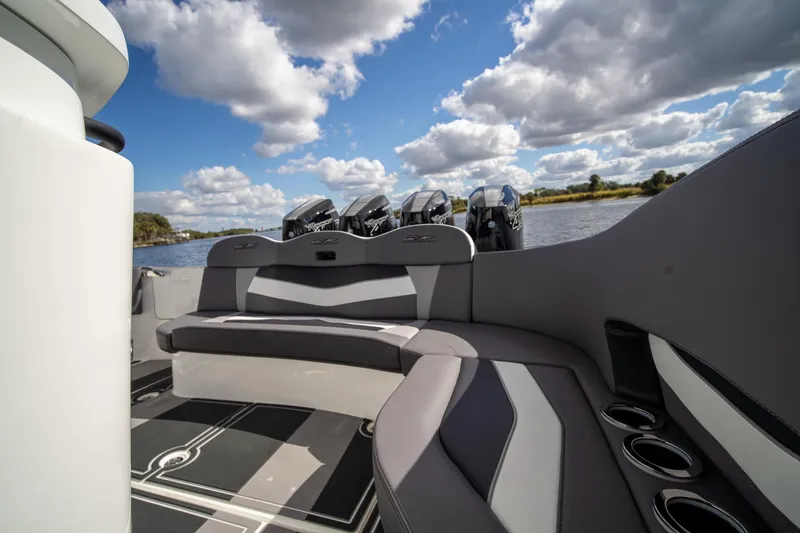 Slide: The Image of Luxurious MTI V42 boat interior with seating, cup holders, and outboard motors under a cloudy sky. - 22