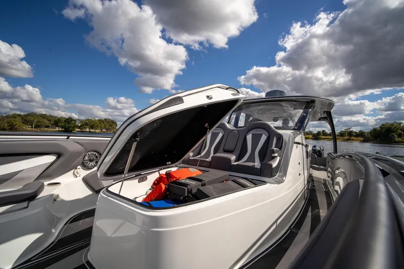 Slide: The Image of 2020 MTI V42 boat with open storage, sleek design, under a partly cloudy sky. - 28