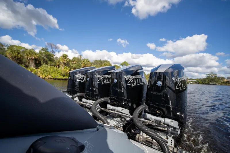 Slide: The Image of Four powerful outboard motors on an MTI V42 boat, 2020 model, cruising on a sunny day. - 3