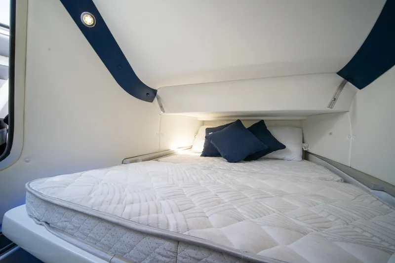 Slide: The Image of Cozy cabin bed in 2020 MTI V42 boat with blue accents and pillows. - 45