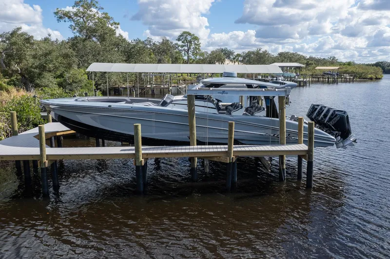 Slide: The Image of 2020 MTI V42 boat docked on a wooden pier by a scenic river. - 50