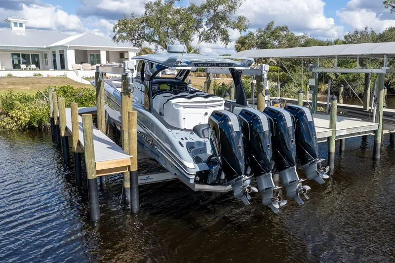 Slide: The Image of MTI V42 2020 boat with four engines docked near a waterfront house. - 51