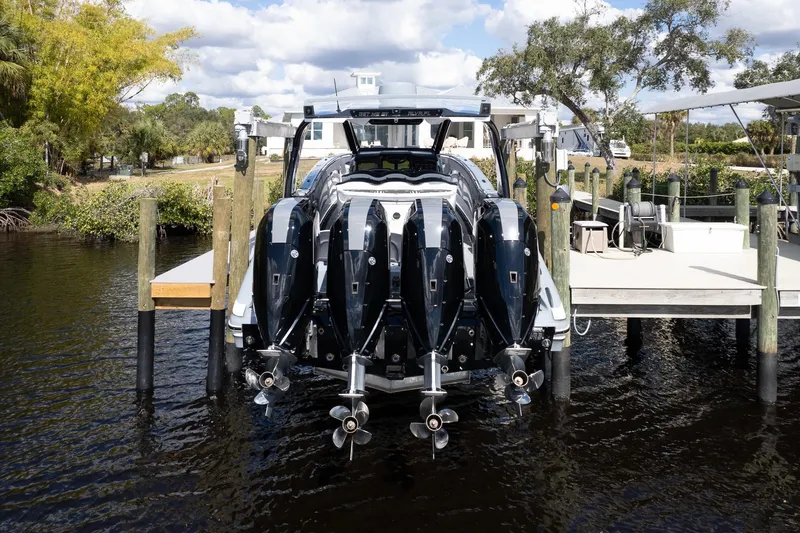 Slide: The Image of 2020 MTI V42 boat with four powerful outboard engines docked by a scenic waterfront. - 52