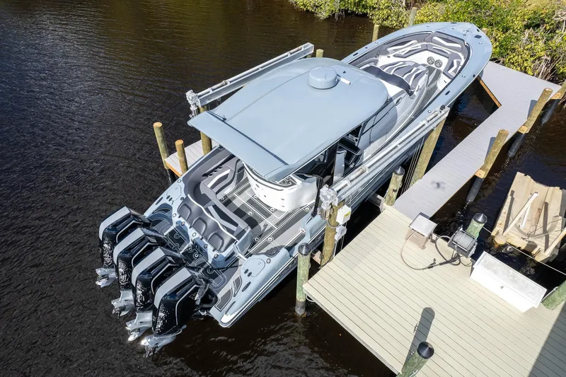 Slide: The Image of Aerial view of 2020 MTI V42 boat docked, featuring sleek design and multiple outboard engines. - 54