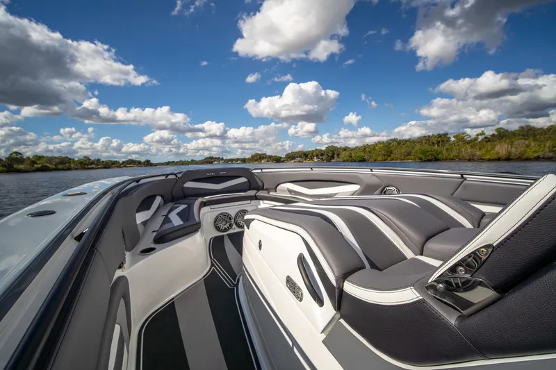 Slide: The Image of Luxurious MTI V42 boat interior with sleek seating, set against a scenic waterway and cloudy sky. - 6