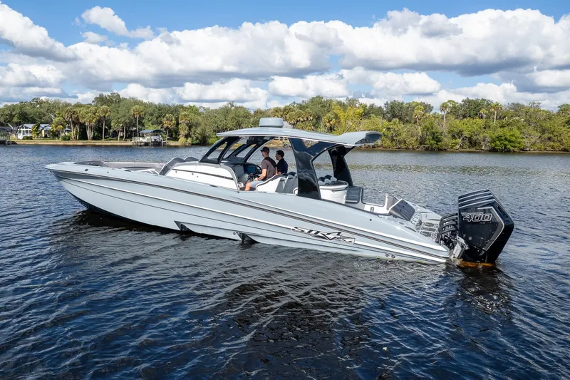 Slide: The Image of 2020 MTI V42 boat on a calm river with lush green shoreline. - 66