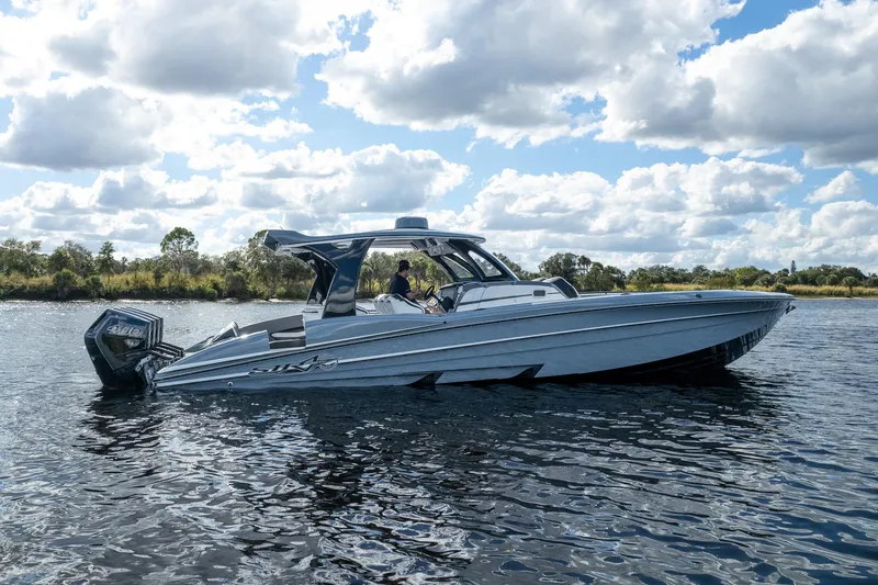 Slide: The Image of 2020 MTI V42 boat cruising on a calm lake under a partly cloudy sky. - 67
