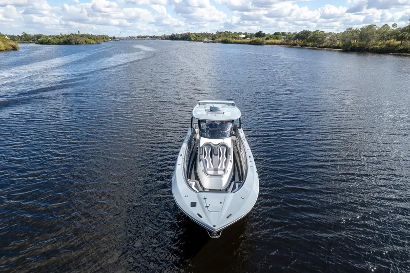 Slide: The Image of 2020 MTI V42 boat cruising on a scenic river under a cloudy sky. - 69