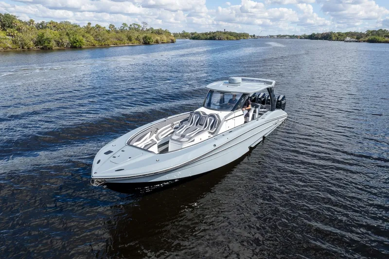 Slide: The Image of 2020 MTI V42 boat cruising on a scenic river under a partly cloudy sky. - 70
