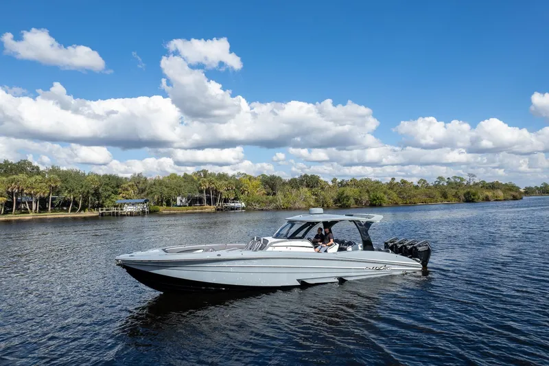 Slide: The Image of 2020 MTI V42 boat cruising on a scenic river under a blue sky with clouds. - 71