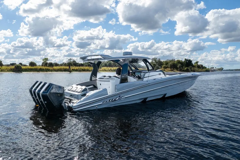 Slide: The Image of 2020 MTI V42 boat on a calm lake under a cloudy sky. - 84
