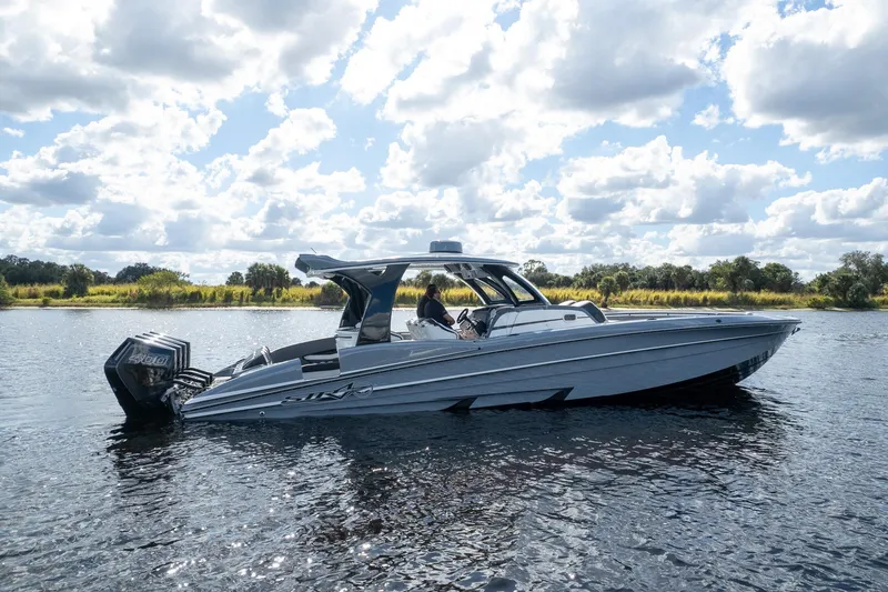 Slide: The Image of 2020 MTI V42 boat cruising on a sunny day with scenic water and sky. - 85