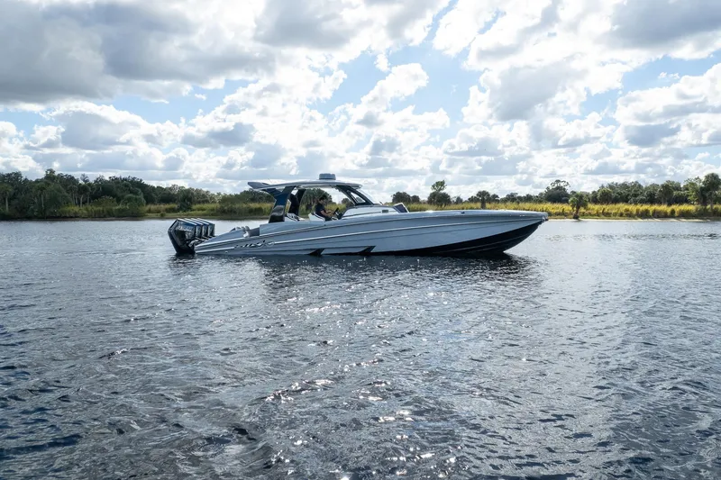 Slide: The Image of 2020 MTI V42 boat cruising on a scenic lake under a cloudy sky. - 87