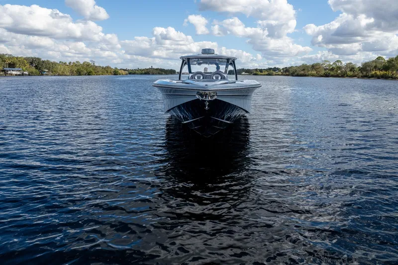 Slide: The Image of MTI V42 boat on a calm river under a partly cloudy sky, 2020 model. - 89