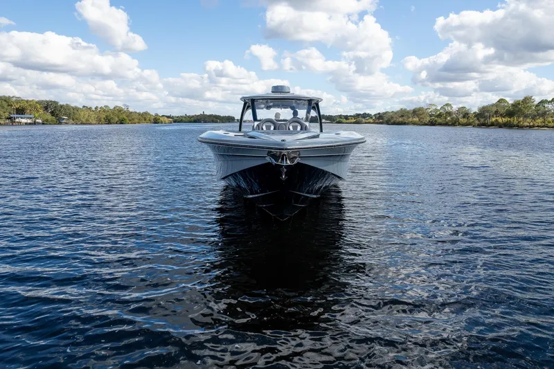 Slide: The Image of 2020 MTI V42 boat on calm water under a partly cloudy sky. - 90