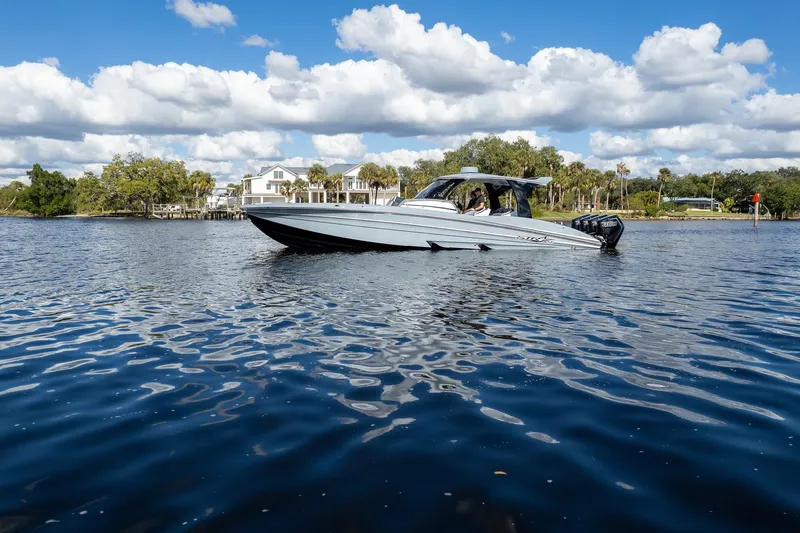 Slide: The Image of 2020 MTI V42 boat cruising on a scenic lake under a blue sky. - 91