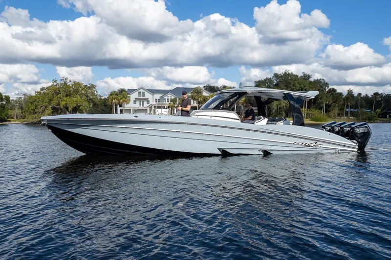 Slide: The Image of 2020 MTI V42 boat on a calm lake under a partly cloudy sky. - 96