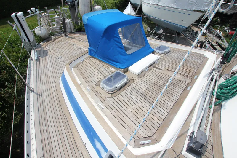 Slide: The Image of Deck of 1990 Nautor Swan 61 sailboat with blue canopy and wooden finish. - 10