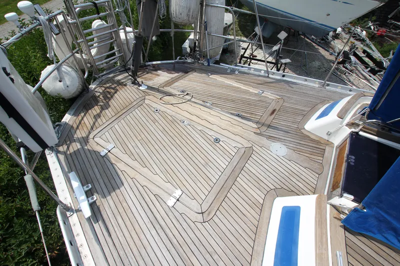 Slide: The Image of Teak deck of 1990 Nautor Swan 61 yacht, featuring clean lines and stainless steel fittings. - 11