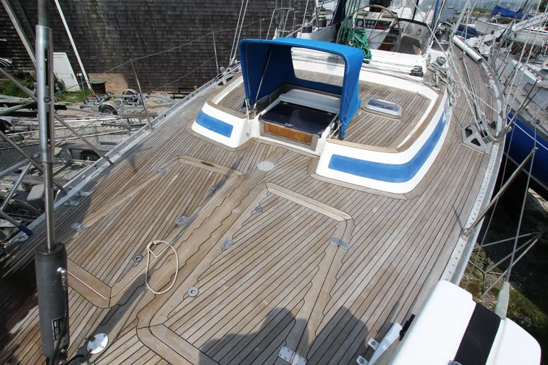 Slide: The Image of Teak deck of 1990 Nautor Swan 61 sailboat with blue accents and cockpit cover. - 12