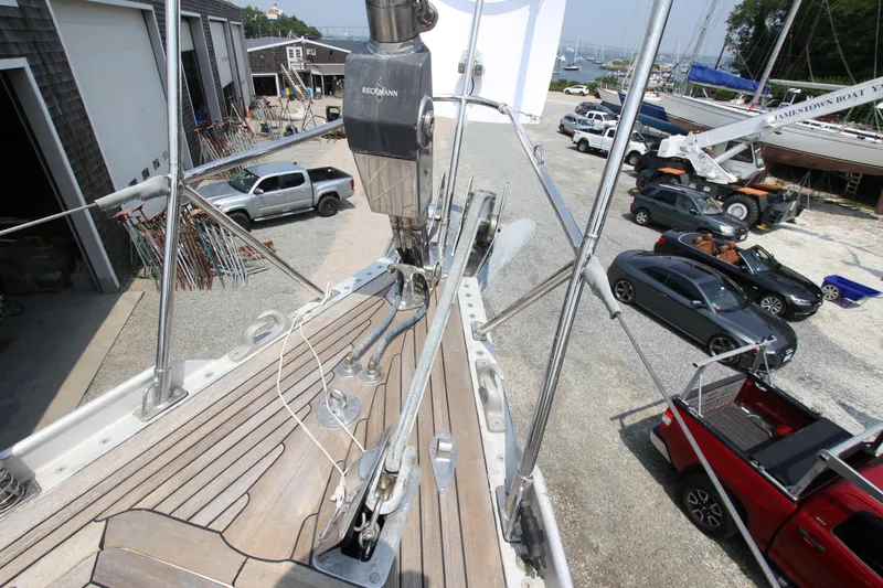 Slide: The Image of Deck view of 1990 Nautor Swan 61 sailboat in a boatyard with parked vehicles. - 2