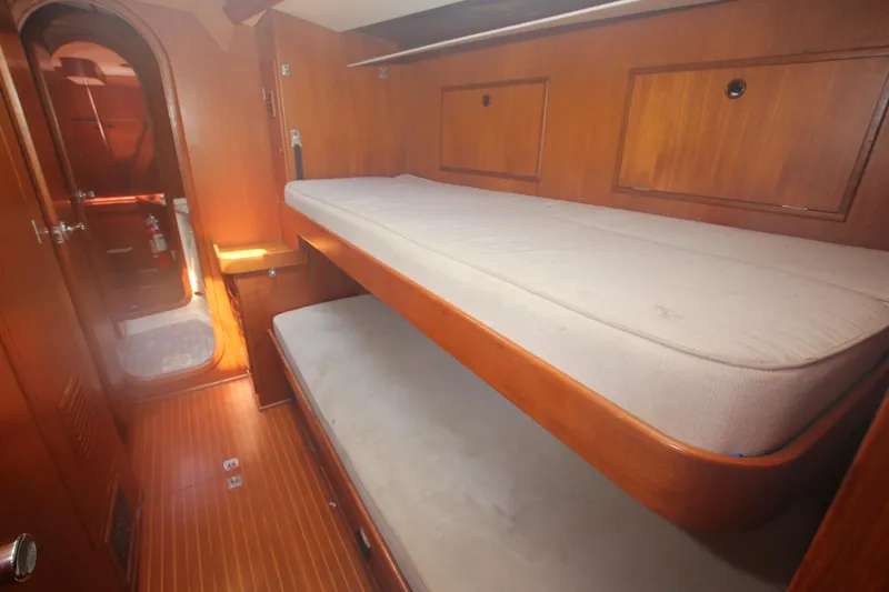 Slide: The Image of Interior of 1990 Nautor Swan 61 yacht with wooden bunk beds and cozy cabin design. - 23