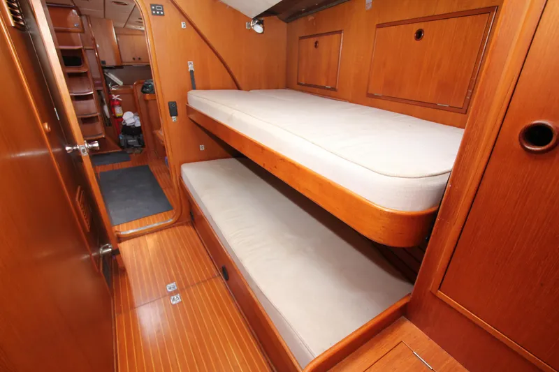 Slide: The Image of Interior of 1990 Nautor Swan 61 yacht with wooden bunk beds and storage. - 24