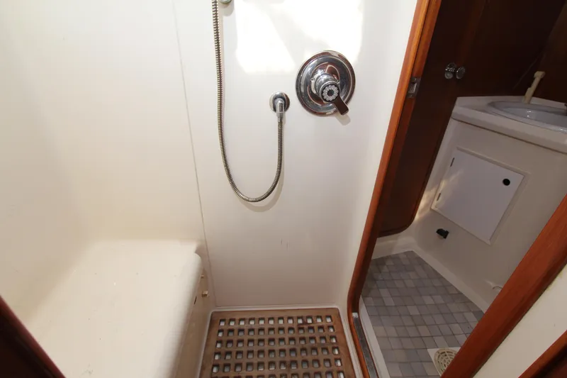Slide: The Image of Shower area in 1990 Nautor Swan 61 yacht, featuring wooden grate and compact design. - 26