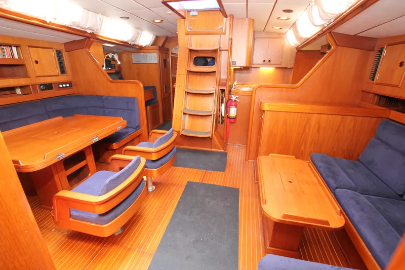 Slide: The Image of Luxurious 1990 Nautor Swan 61 yacht interior with wooden furnishings and blue seating. - 27