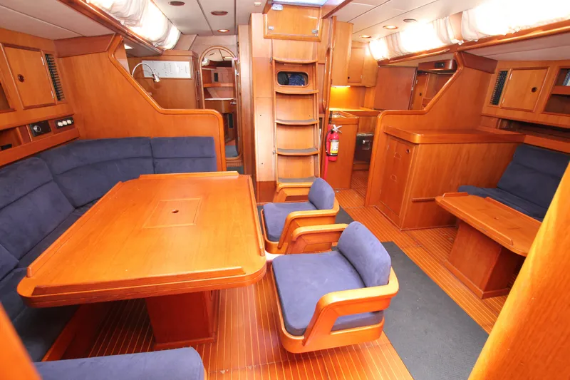 Slide: The Image of Luxurious 1990 Nautor Swan 61 yacht interior with wooden furnishings and blue seating. - 28