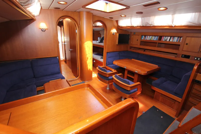 Slide: The Image of Luxurious interior of 1990 Nautor Swan 61 yacht with wooden furnishings and blue seating. - 29