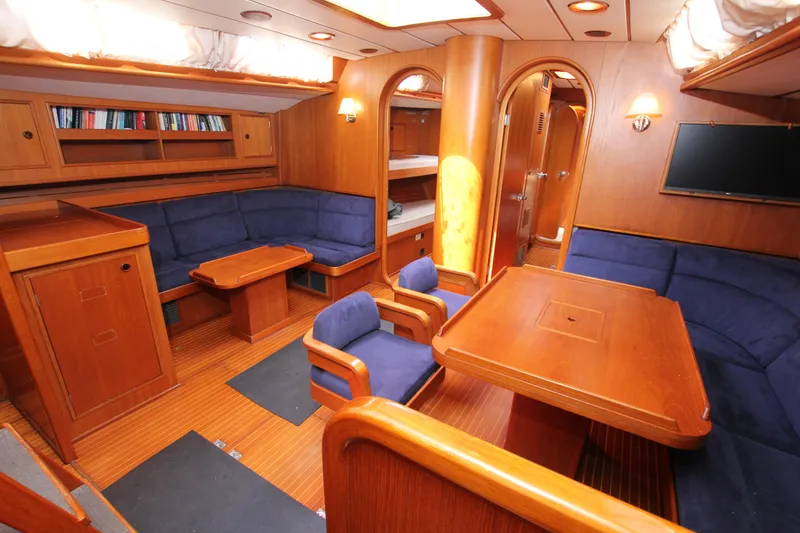 Slide: The Image of Luxurious 1990 Nautor Swan 61 yacht interior with wooden furnishings and blue seating. - 30