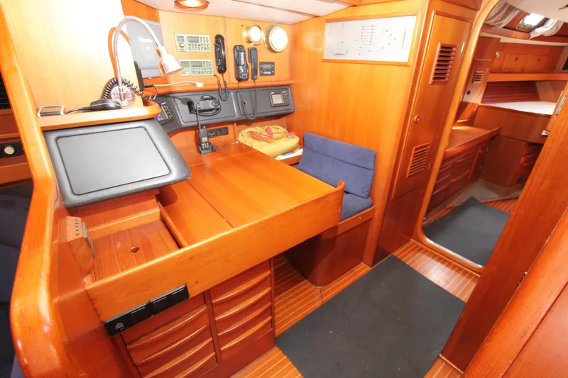 Slide: The Image of Nautor Swan 61 yacht interior, 1990 model, featuring navigation station and wooden cabinetry. - 34