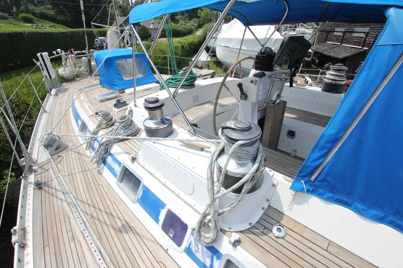 Slide: The Image of Swan 61 sailboat deck with blue canopy, ropes, and winches, 1990 model. - 9