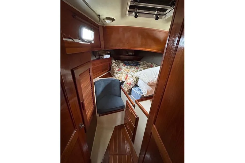 Slide: The Image of 1990 Pacific Seacraft PSC 37 cabin interior with wooden finish and cozy bedding. - 9