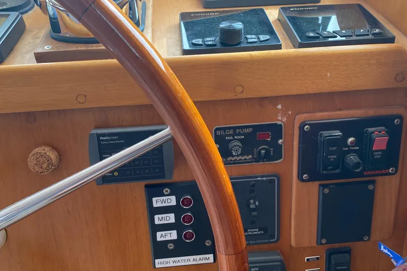 Slide: The Image of 1987 Jarvis Newman 46' Flybridge Cruiser helm with controls and wooden steering wheel. - 25