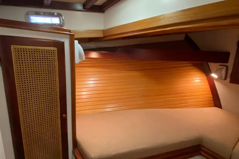 Slide: The Image of 1987 Jarvis Newman 46' Flybridge Cruiser cabin with wooden interior and cozy bed. - 31