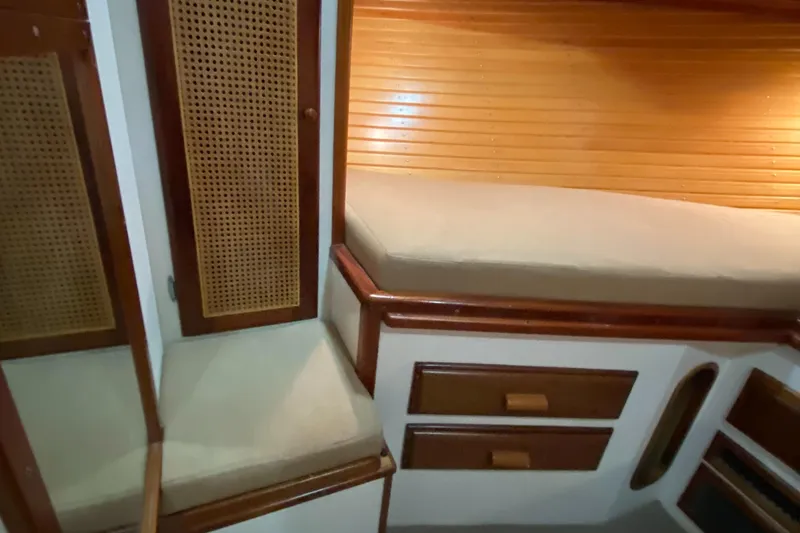 Slide: The Image of 1987 Jarvis Newman 46' Flybridge Cruiser cabin interior with wooden accents and cushioned seating. - 32