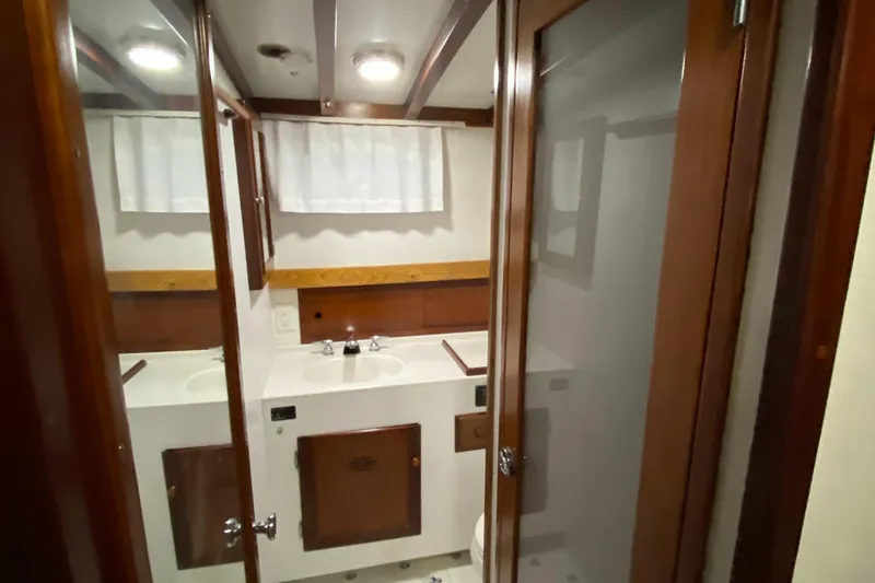 Slide: The Image of Bathroom interior of 1987 Jarvis Newman 46' Flybridge Cruiser, featuring wood accents and mirrored cabinets. - 42