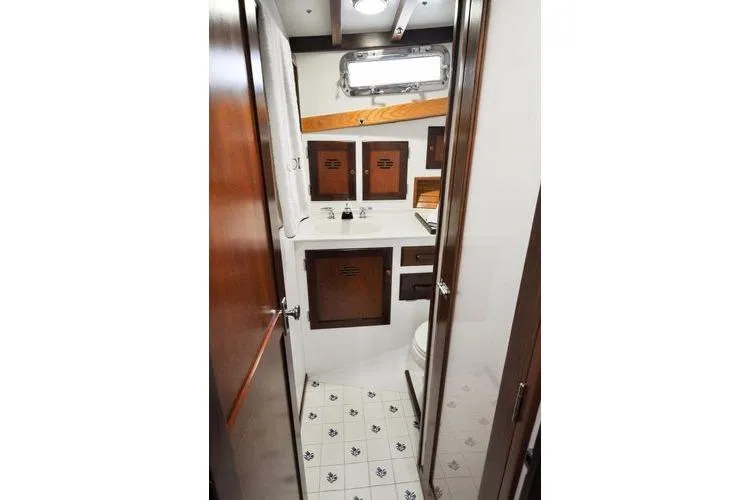 Slide: The Image of 1987 Jarvis Newman 46' Flybridge Cruiser bathroom with wooden cabinets and nautical decor. - 43