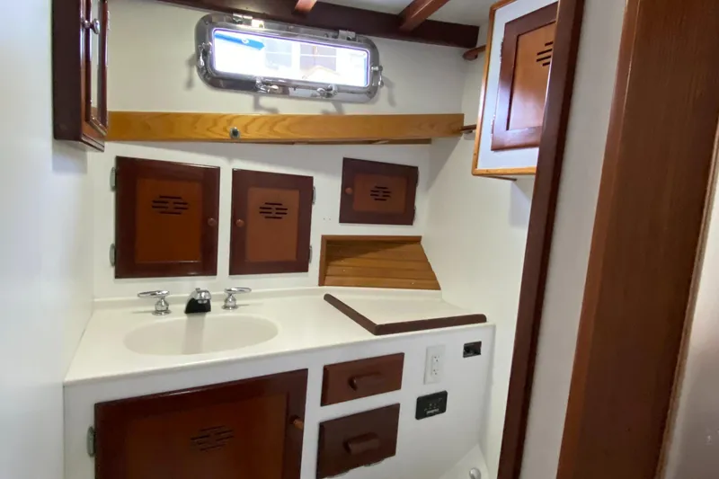 Slide: The Image of 1987 Jarvis Newman 46' Flybridge Cruiser bathroom with wooden cabinets and white sink. - 44