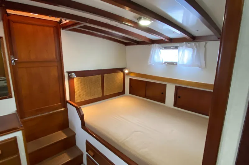 Slide: The Image of 1987 Jarvis Newman 46' Flybridge Cruiser cabin with wooden interior and cozy bed. - 52