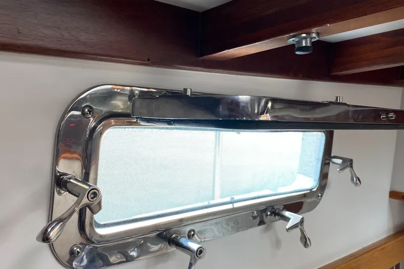 Slide: The Image of 1988 Jarvis Newman 46' Flybridge Downeast yacht window with stainless steel frame and wooden trim. - 55