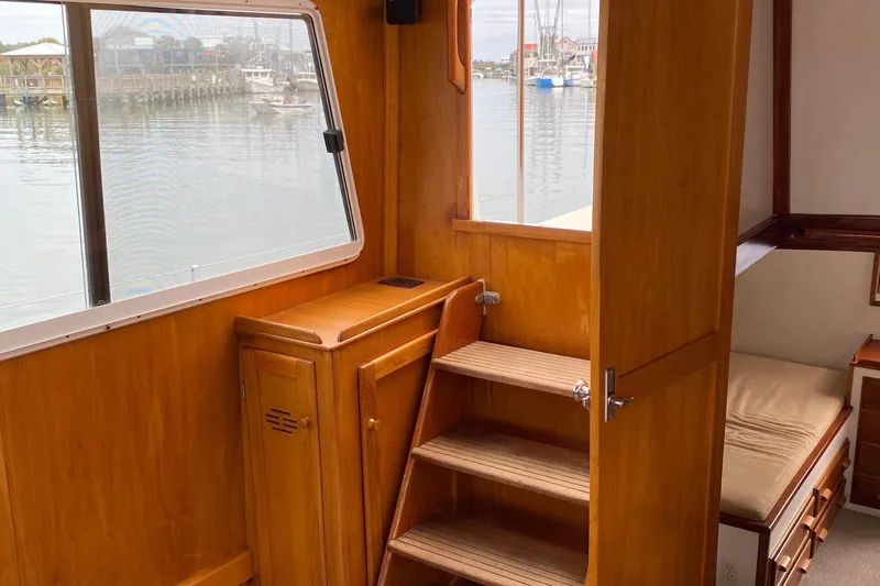 Slide: The Image of Interior of 1987 Jarvis Newman 46' Flybridge Cruiser with wooden cabinetry and window view. - 56
