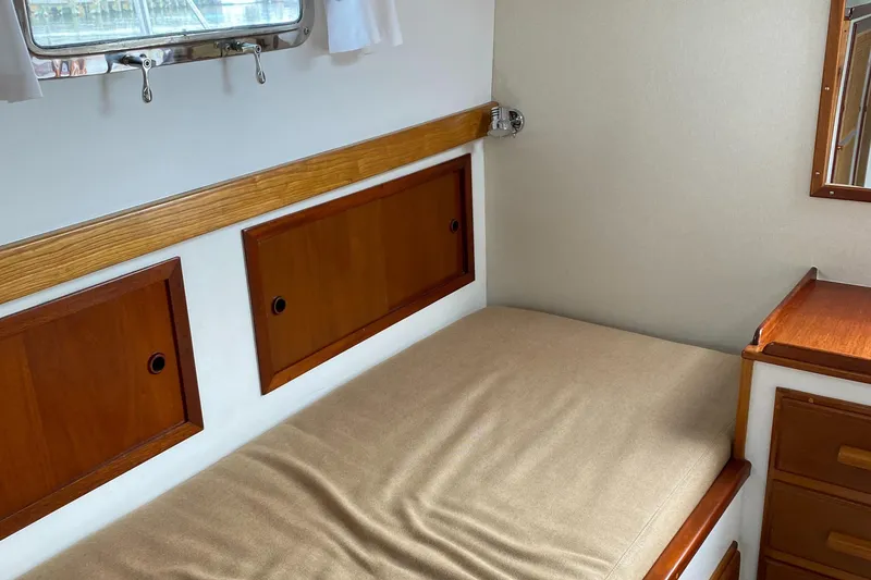Slide: The Image of 1987 Jarvis Newman 46' Flybridge Cruiser cabin with wooden storage and bed. - 57